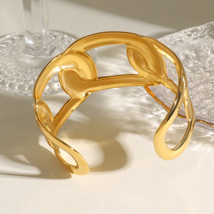 Brazalete abierto ancho de acero inoxidable bañado en oro con forma ovalada