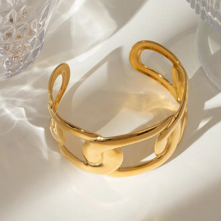 Brazalete abierto ancho de acero inoxidable bañado en oro con forma ovalada